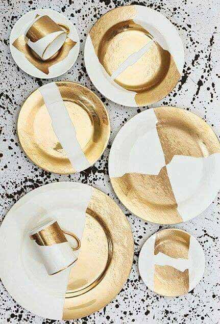 White tableware painted with broad gold shapes on a speckled surface